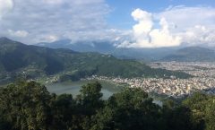 Het Phewa meer met Pokhara stad ernaast en de Annapurna bergketen op de achtergrond